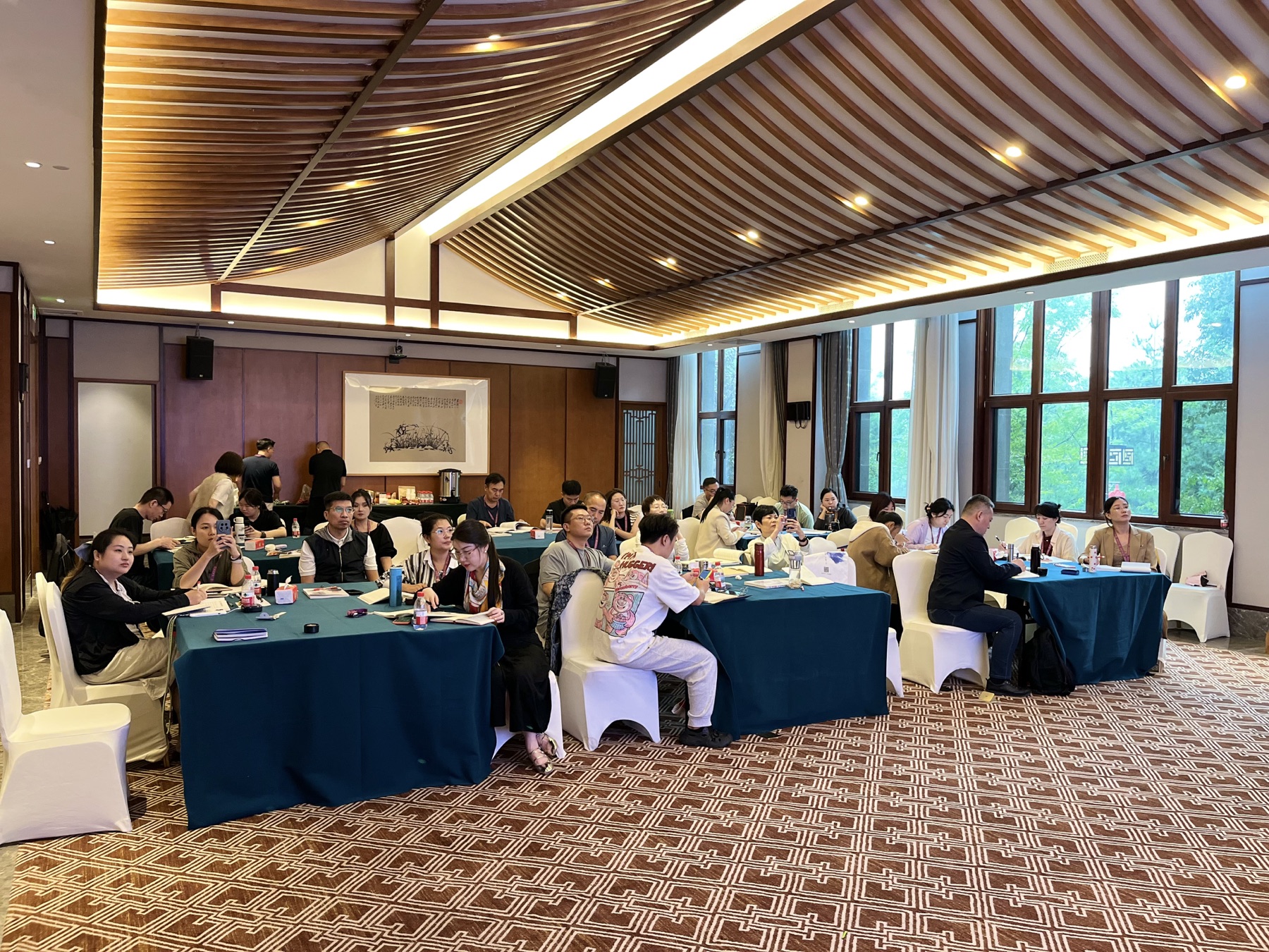 课堂中的学员倾听、讨论并记录学习内容